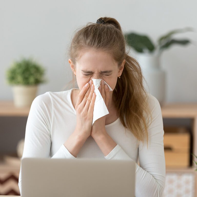 Woman blowing her nose